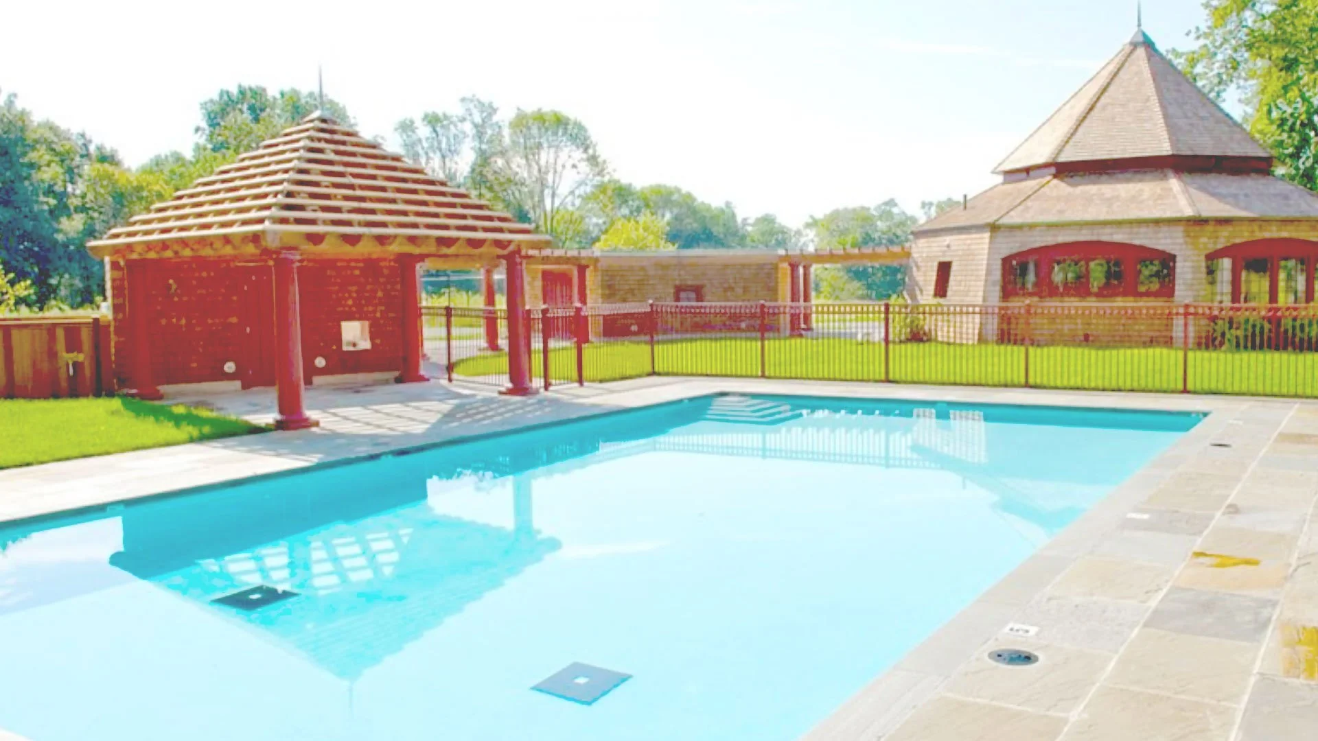 Swimming pool beside the poolhouse and covered outdoor room
